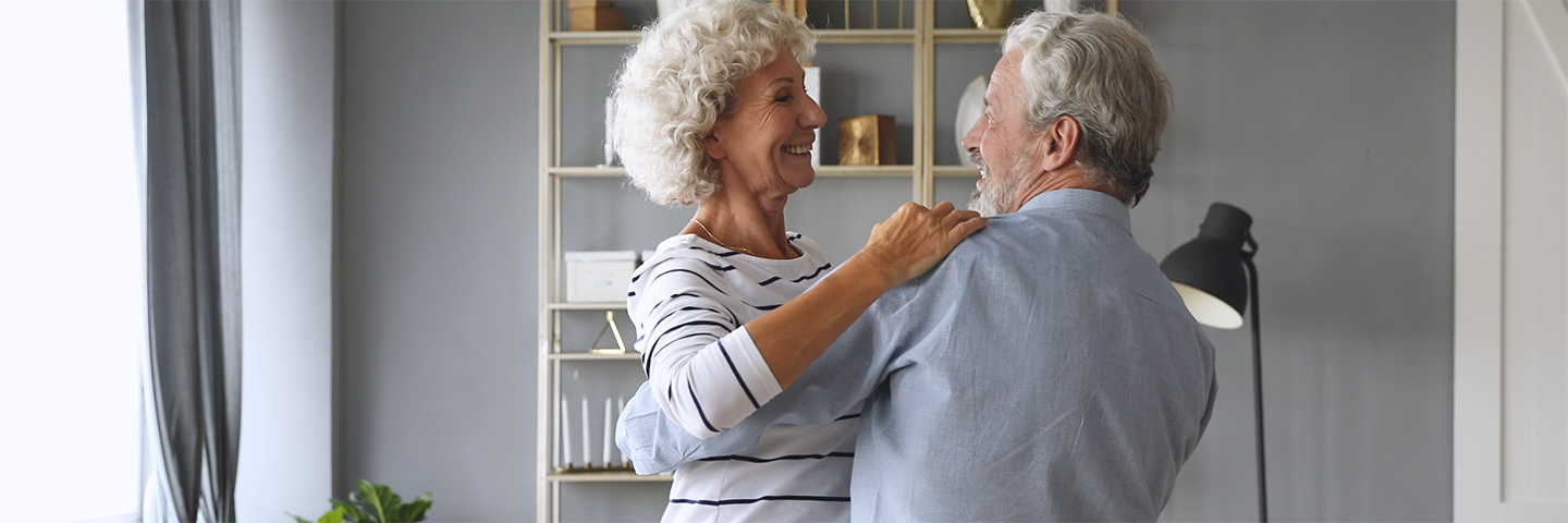 Een ouder stel danst in de woonkamer