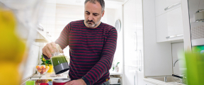 Een man bezig met bewust eten in de keuken.