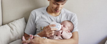 Man geeft flesje melk aan baby