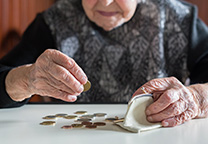 Oude vrouw stopt muntgeld in portemonnee