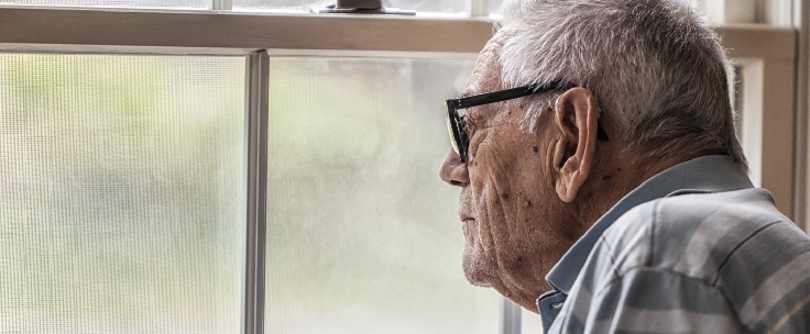 Oudere man staart uit het raam