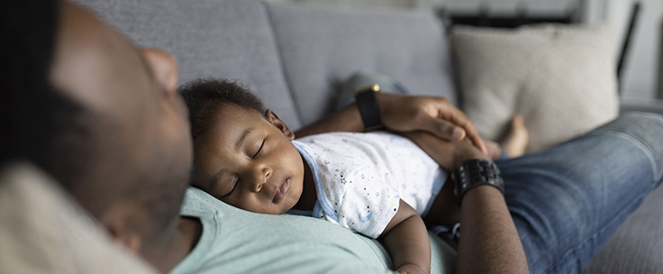Baby ligt op borst van vader