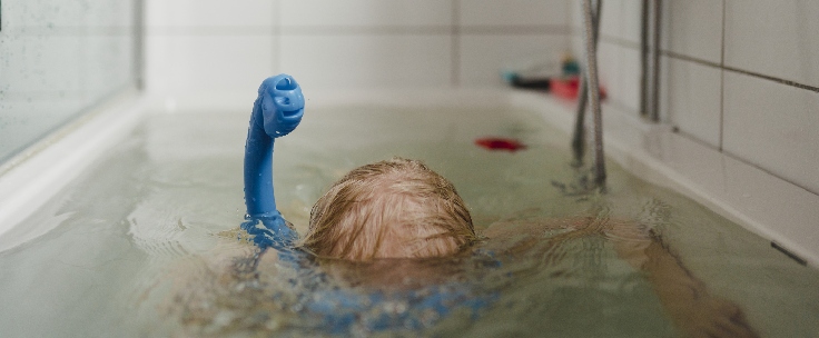 Kind met duikbril in bad