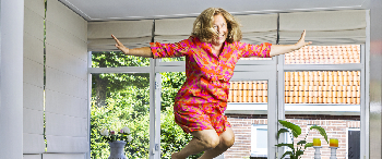 Vrouw springt op trampoline in woonkamer