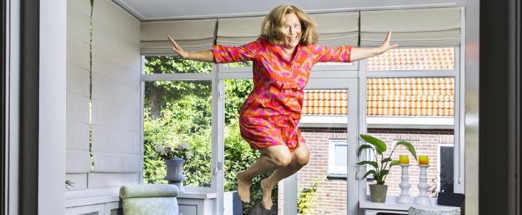Vrouw springt op trampoline in woonkamer