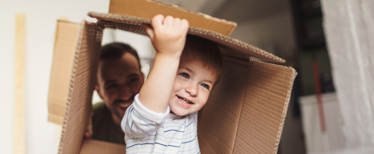 Kleine jongen speelt met kartonnen doos