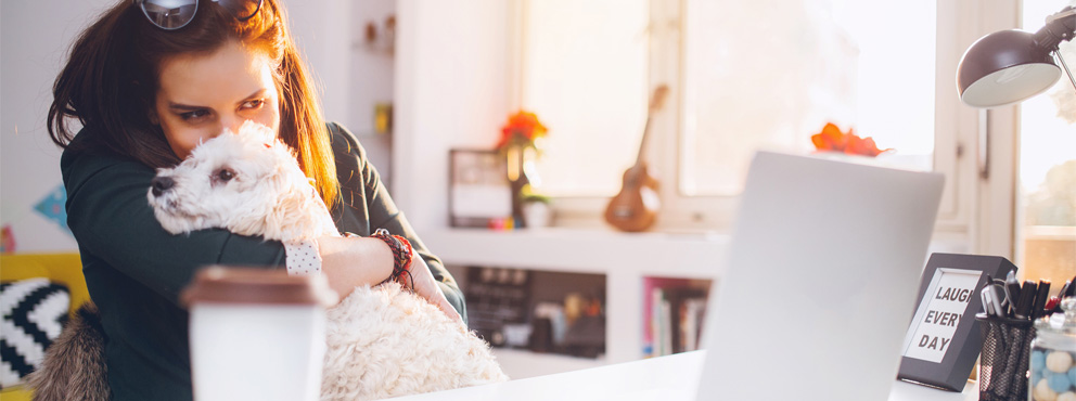 vrouw met hond achter laptop