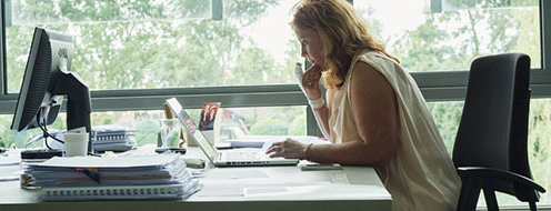 Vrouw achter bureau aan telefoon